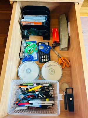 DESK DRAWER PACKED WITH DIFFERENT OFFICE SUPPLIES