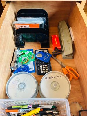 DESK DRAWER PACKED WITH DIFFERENT OFFICE SUPPLIES