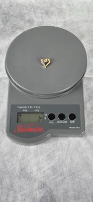 Lot 43: 14k Gold Heart Shaped Pendant with Baguette Diamonds / 1g