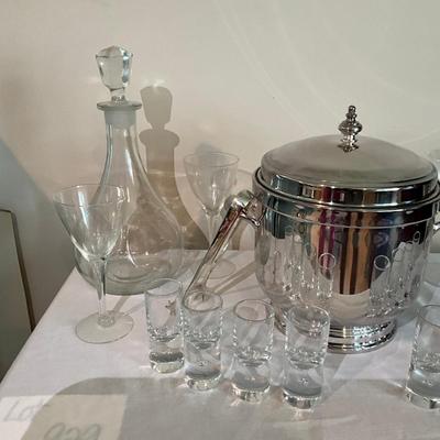 Sale Photo Thumbnail #1245: Decanter, 8 shot glasses, 2 small champagne glasses, 3 martini glasses, ice bucket with tongs (silver plated)
Ice bucket: 9" high x 7.5" wide
Decanter: 11" high