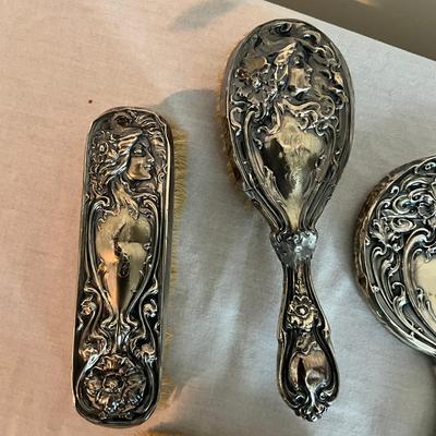 Sale Photo Thumbnail #1272: Three silver brushes in art nouveau style marked  925
Mirror is 9" long
Big brush is 8.5" long