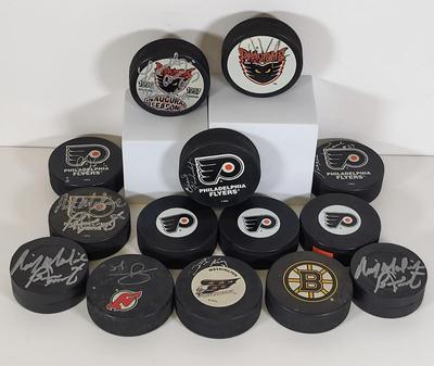 LOT 93: Many Autographed Hockey Pucks by Various Players from Philadelphia Flyers, New Jersey Devils and More