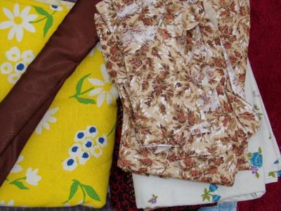 A pile of fabric in a box plus a dress pattern w/fabric & buttons,