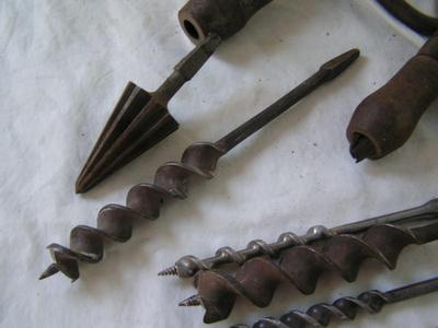 A pair of hand drill braces w/ a collection of drill bits in a wooden box.