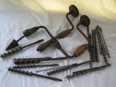 A pair of hand drill braces w/ a collection of drill bits in a wooden box.
