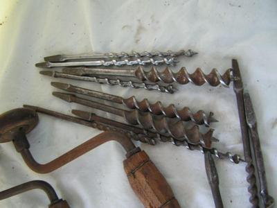 A pair of hand drill braces w/ a collection of drill bits in a wooden box.