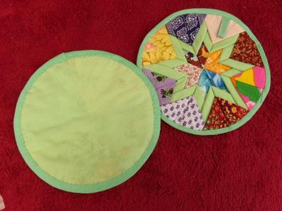 A pair of nicely made quilted hot pads, appear hand crafted.