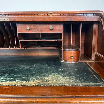 Sale Photo Thumbnail #217: Beautiful Angus of London Roll Top Tambour Desk with 8 drawers, eagle lock co brass hardware, brass pulls & know, missing one castor wheel, leather top has some wear 43" high x 48" wide x 27" deep desk height is 30.5"