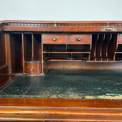 Sale Photo Thumbnail #218: Beautiful Angus of London Roll Top Tambour Desk with 8 drawers, eagle lock co brass hardware, brass pulls & know, missing one castor wheel, leather top has some wear 43" high x 48" wide x 27" deep desk height is 30.5"