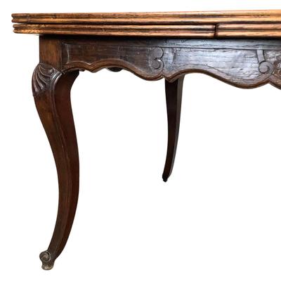 Sale Photo Thumbnail #239: Solid oak table with a burl wood top adding a rich warm patina that speaks to its age and quality. The table boasts intricate carvings along its edges and legs, showcasing the craftsmanship of the period. Its extendable design allows for versatile seating