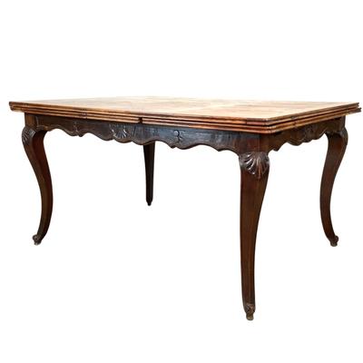 Sale Photo Thumbnail #236: Solid oak table with a burl wood top adding a rich warm patina that speaks to its age and quality. The table boasts intricate carvings along its edges and legs, showcasing the craftsmanship of the period. Its extendable design allows for versatile seating