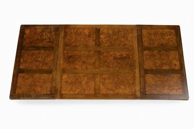 Sale Photo Thumbnail #240: Solid oak table with a burl wood top adding a rich warm patina that speaks to its age and quality. The table boasts intricate carvings along its edges and legs, showcasing the craftsmanship of the period. Its extendable design allows for versatile seating