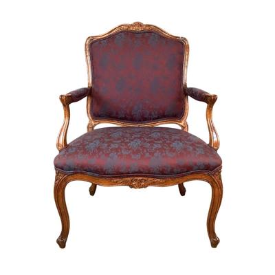 Sale Photo Thumbnail #257: magnificent example of 18th-century French craftsmanship, this Louis XV fauteuil armchair exudes elegance and comfort. Carved from rich walnut, the chair boasts a beautifully detailed frame showcasing the flowing lines and delicate asymmetry characteristi