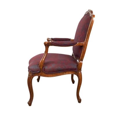 Sale Photo Thumbnail #258: magnificent example of 18th-century French craftsmanship, this Louis XV fauteuil armchair exudes elegance and comfort. Carved from rich walnut, the chair boasts a beautifully detailed frame showcasing the flowing lines and delicate asymmetry characteristi