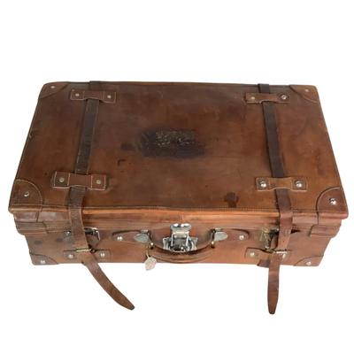 Sale Photo Thumbnail #275: Reinforced exposed straps, handles, chrome latches, includes working key, original pale blue textile interior, one ripped strapped everything else leather is intact. Rich dark leather patina. 30" wide x 11.5" high x 17" deep.