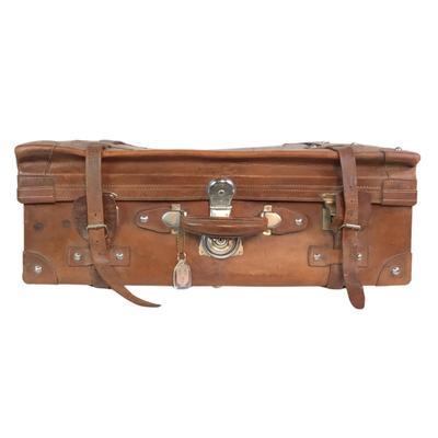 Sale Photo Thumbnail #274: Reinforced exposed straps, handles, chrome latches, includes working key, original pale blue textile interior, one ripped strapped everything else leather is intact. Rich dark leather patina. 30" wide x 11.5" high x 17" deep.