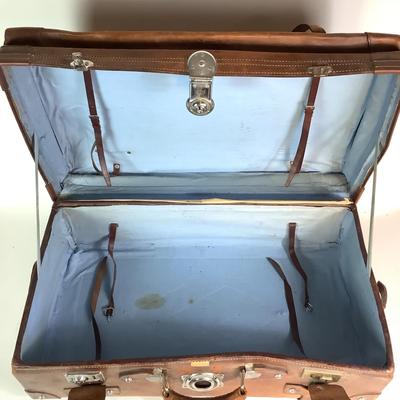 Sale Photo Thumbnail #283: Reinforced exposed straps, handles, chrome latches, includes working key, original pale blue textile interior, one ripped strapped everything else leather is intact. Rich dark leather patina. 30" wide x 11.5" high x 17" deep.
