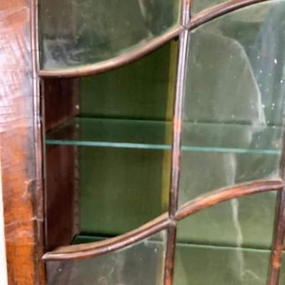 Sale Photo Thumbnail #335: 18th or early 19th century Continental vitrine, applied shell frieze at the top, arched mullions over glass, with compass inlay on the veneered bottom half, scalloped base, claw on ball feet. It has a built in light switch that plugs into the wall and it 