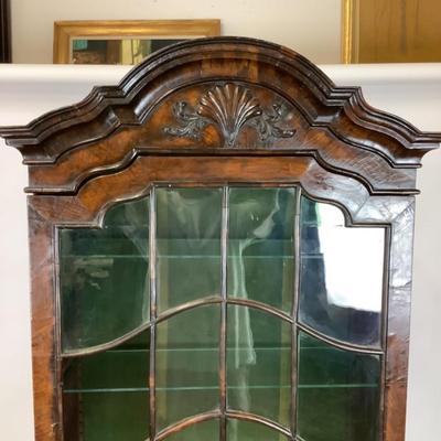 Sale Photo Thumbnail #333: 18th or early 19th century Continental vitrine, applied shell frieze at the top, arched mullions over glass, with compass inlay on the veneered bottom half, scalloped base, claw on ball feet. It has a built in light switch that plugs into the wall and it 
