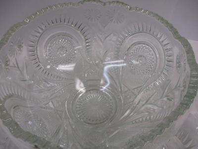 Sale Photo Thumbnail #397: The product is an antique EAPG (Early American Pattern Glass) punch bowl and underplate made by the U.S. Glass Co. The intricate design features a slanted horseshoe and radial daisy pattern, adding a touch of elegance to any dining or kitchen decor. The g