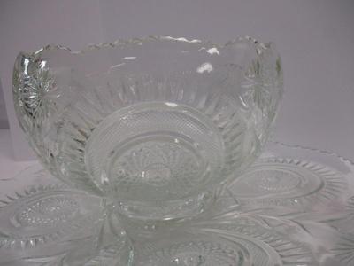 Sale Photo Thumbnail #396: The product is an antique EAPG (Early American Pattern Glass) punch bowl and underplate made by the U.S. Glass Co. The intricate design features a slanted horseshoe and radial daisy pattern, adding a touch of elegance to any dining or kitchen decor. The g