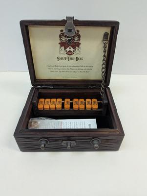 Sale Photo Thumbnail #1544: The Shut-the-Box game by GAME is a traditional game that involves rolling two dice and covering the corresponding numbers on a wooden board. Players take turns rolling the dice and trying to shut the box by covering the corresponding numbers. The game is 