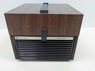 Sale Photo Thumbnail #1947: The Bell & Howell Slide Cube Projector Model 981Q is a high-quality slide projector designed by the well-known brand Bell and Howell. Featuring a unique cube design, this model allows for easy slide transitions and provides a clear and vibrant projection.