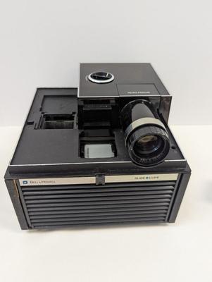 Sale Photo Thumbnail #1952: The Bell & Howell Slide Cube Projector Model 981Q is a high-quality slide projector designed by the well-known brand Bell and Howell. Featuring a unique cube design, this model allows for easy slide transitions and provides a clear and vibrant projection.