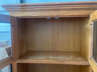 Sale Photo Thumbnail #897: Tall Wooden Hutch with Glass Inserts. Glass is removable, doors have magnetic closures. Plus an extra pull out serving surface. Huge amount of storage. Some sun bleaching on the upper cabinets and missing some of the magnetic closures, but otherwise good 