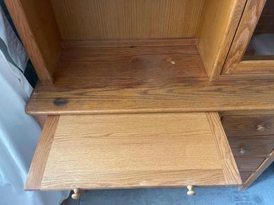 Sale Photo Thumbnail #899: Tall Wooden Hutch with Glass Inserts. Glass is removable, doors have magnetic closures. Plus an extra pull out serving surface. Huge amount of storage. Some sun bleaching on the upper cabinets and missing some of the magnetic closures, but otherwise good 