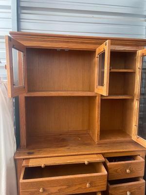 Sale Photo Thumbnail #895: Tall Wooden Hutch with Glass Inserts. Glass is removable, doors have magnetic closures. Plus an extra pull out serving surface. Huge amount of storage. Some sun bleaching on the upper cabinets and missing some of the magnetic closures, but otherwise good 