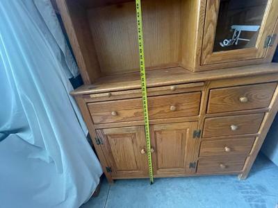 Sale Photo Thumbnail #902: Tall Wooden Hutch with Glass Inserts. Glass is removable, doors have magnetic closures. Plus an extra pull out serving surface. Huge amount of storage. Some sun bleaching on the upper cabinets and missing some of the magnetic closures, but otherwise good 
