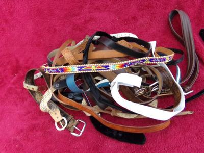 A whole pile of old belts in a box.