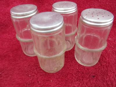 Group of 4 small spice & seasoning bottles w/twist-on lids.