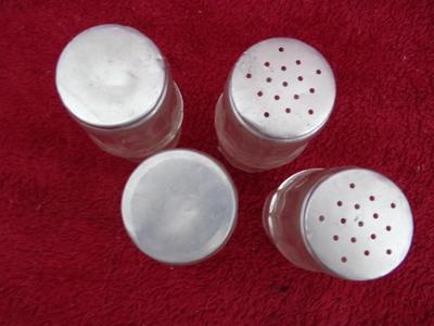Group of 4 small spice & seasoning bottles w/twist-on lids.