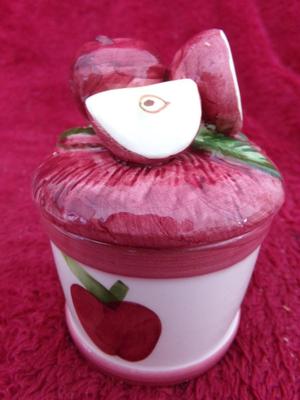 A candle in a ceramic jar. Apples on lid & side of jar. NEW IN BOX