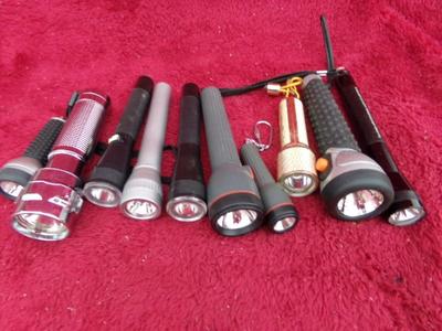 Group of 10 little flashlights in a box. All appear to use “AA” or “AAA”