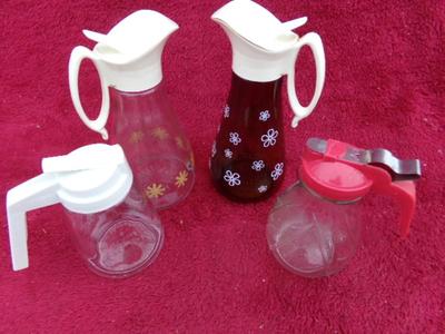 Group of 4 pancake/waffle syrup carafes of various sizes & styles.
