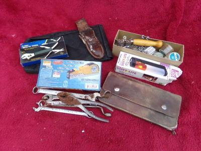 A bunch of tools and leather items, all in a pile.