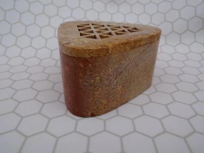 An incense holder for stick incense maybe? Appears to be composite