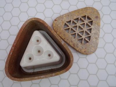 An incense holder for stick incense maybe? Appears to be composite