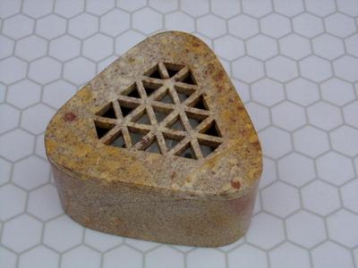 An incense holder for stick incense maybe? Appears to be composite