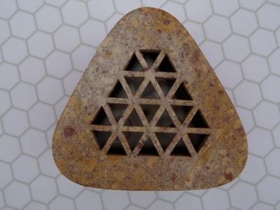 An incense holder for stick incense maybe? Appears to be composite