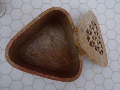 An incense holder for stick incense maybe? Appears to be composite