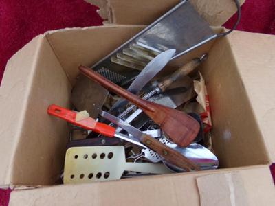 A bundle of kitchen tools and utensils in a box.