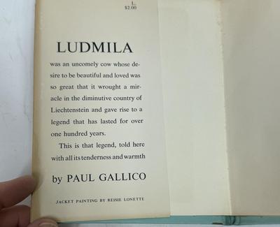 Sale Photo Thumbnail #441: Ludmila: A Legend of Liechtenstein is a 1954 children's book by Paul Gallico about a small cow named Ludmila who wants to win the Liechtenstein harvest ceremony's milk-production competition. The story is set in the Principality of Liechtenstein and featu