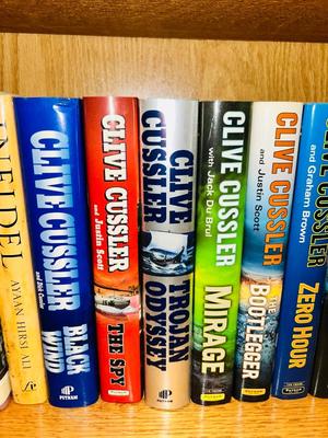 A COLLECTION OF CLIVE CUSSLER, DAVID BALDACCI AND OTHER HARD BACK NOVELS
