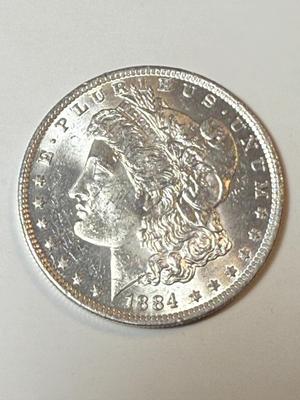 1884-O UNCIRCULATED CONDITION MORGAN SILVER DOLLAR (COIN #1X4) AS PICTURED.