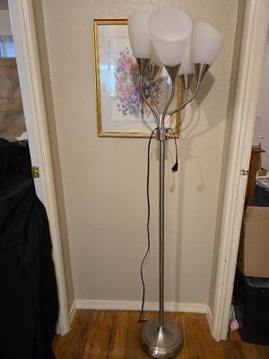 Adjustable armed floor lamp with gold framed wall art pair