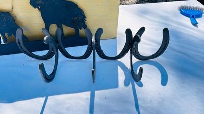 HORSESHOE COAT HOOKS AND A COWBOY IRON WALL CUTOUT